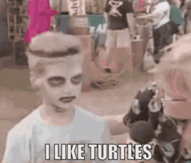 a young boy with zombie makeup on his face is talking to a woman in a crowd .