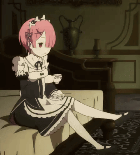 a girl with pink hair is sitting on a couch drinking a cup of tea