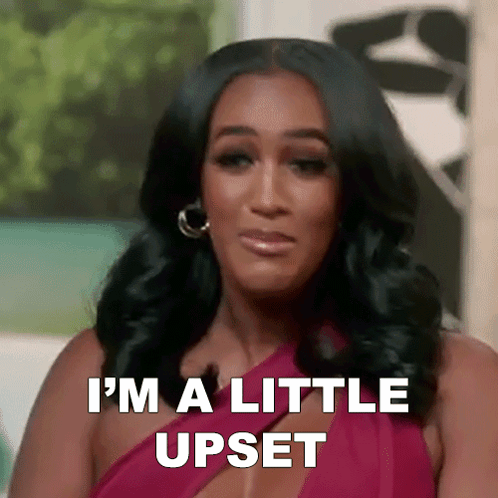 a woman in a red dress is making a funny face and saying i 'm a little upset .