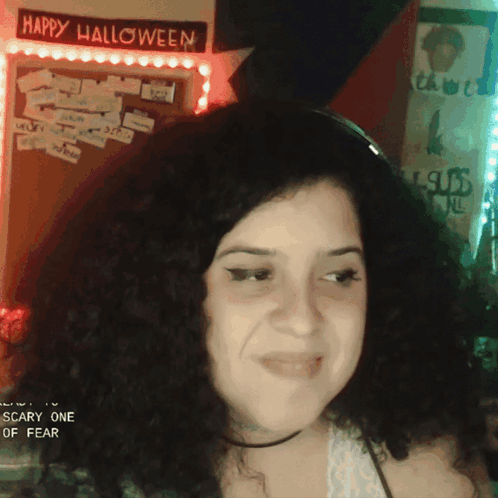 a woman in front of a happy halloween sign
