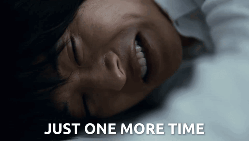 a woman is laying down with her eyes closed and the words just one more time behind her .