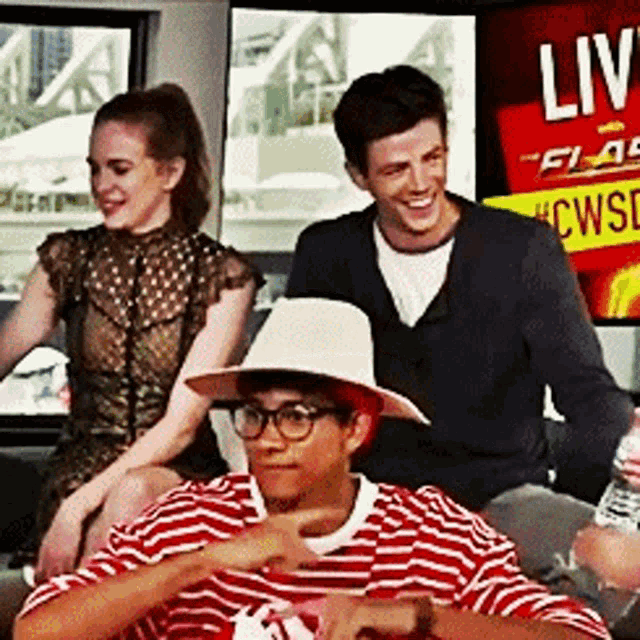 a group of people sitting in front of a sign that says live on it