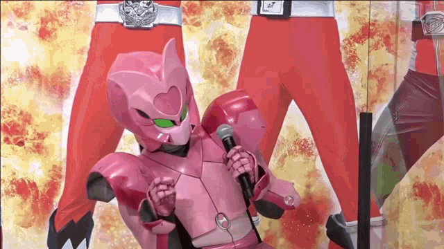 a pink robot is holding a microphone in front of a red man