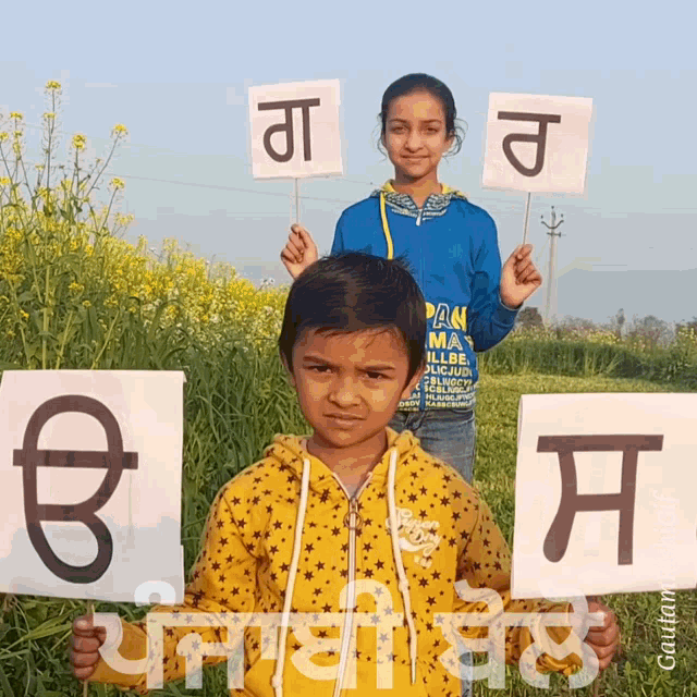 a boy and a girl are holding up signs with punjabi letters