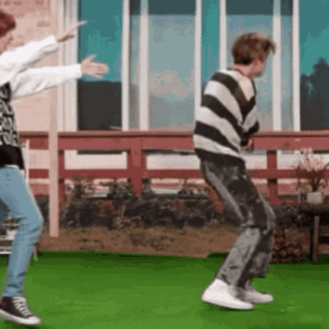 two people are dancing on a green field .