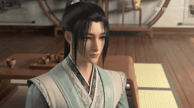 a man with a ponytail is sitting at a table in a room
