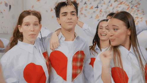 a group of people wearing white shirts with hearts on them