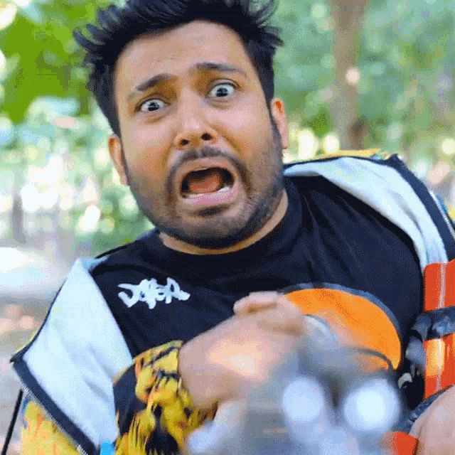 a man with a beard wearing a kappa shirt makes a funny face