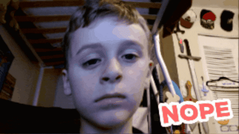 a young boy is looking at the camera with the word nope behind him