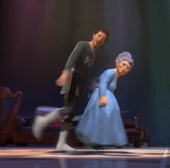 a man and a woman are dancing on a stage and the man has a k on his shirt