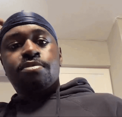 A man in a durag looks directly at the camera, visibly puzzled.