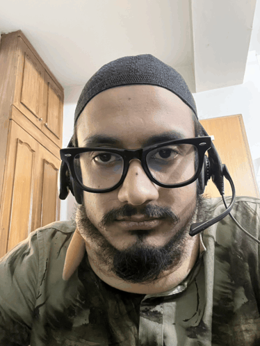 a man with a beard wearing glasses and headphones