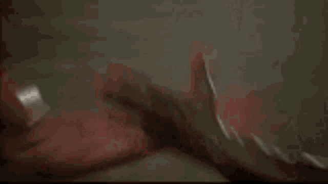 two men are arm wrestling in a gym .