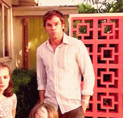 Dexter stands awkwardly in a decorated interior.