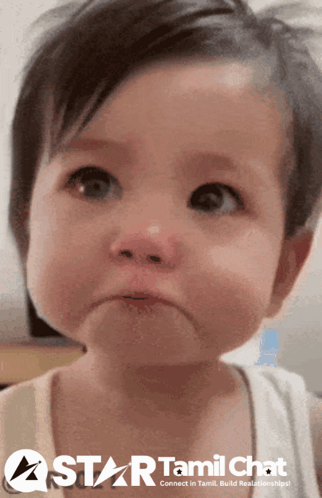 A crying toddler looks upward with tears in their eyes.