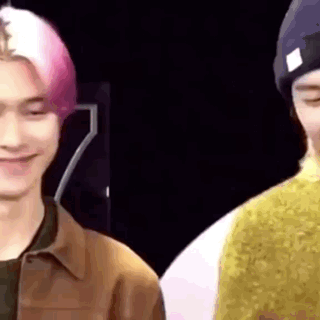 a close up of two men standing next to each other and smiling .