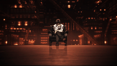 a cartoon character covering his face with his hands while sitting in a chair