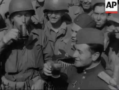a group of soldiers drinking from a cup with the ap logo on the bottom