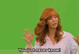 a woman with red hair is waving her hand and says you just never know