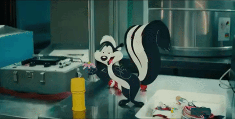 a cartoon squirrel is standing on a counter next to a yellow cylinder .