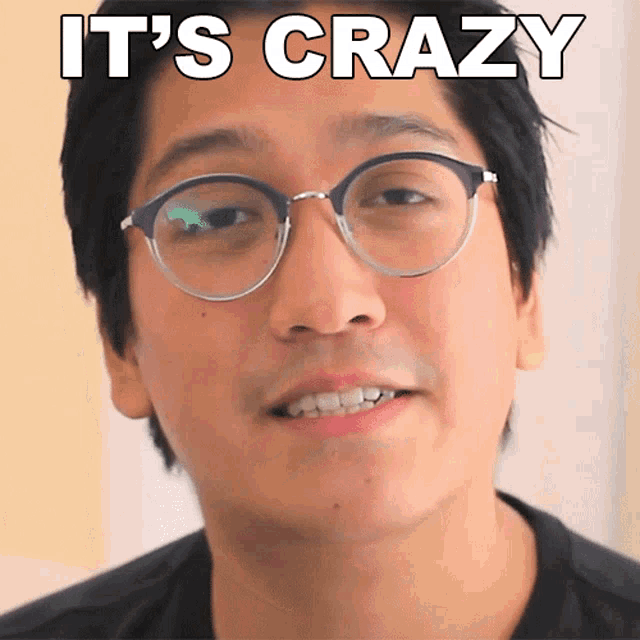 a man wearing glasses with the words it 's crazy above his face