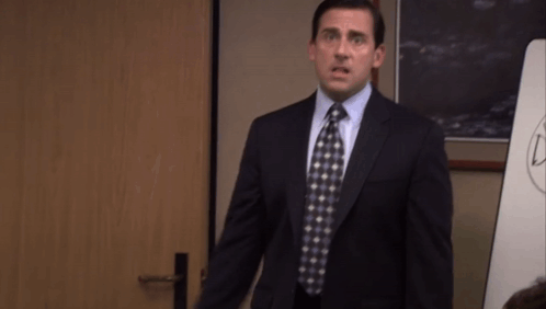 Michael Scott stands in an office doorway looking disappointed.