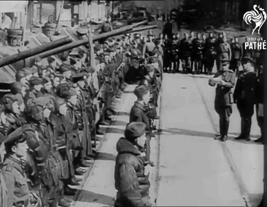a black and white photo of a military parade with the words pathe visible