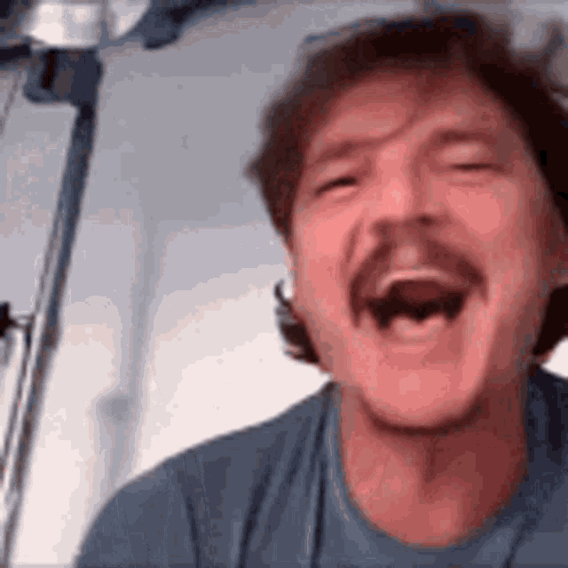 A man laughs loudly in a close-up reaction shot.