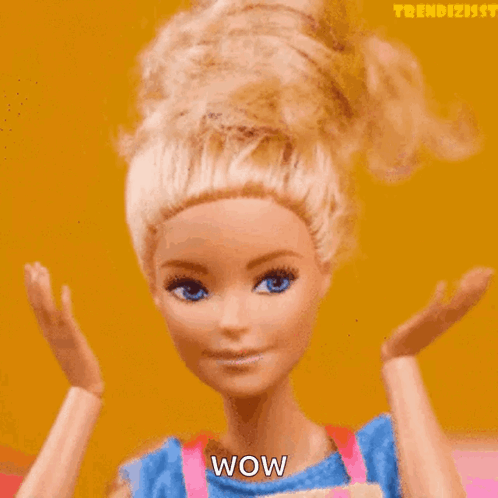 A Barbie doll raises both hands in shocked disbelief.