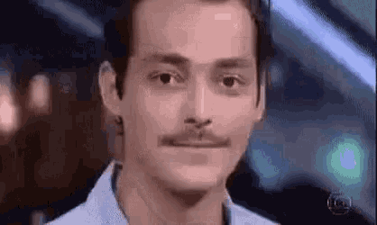 A man holds a tight-lipped expression as if trying not to smile.
