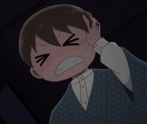 An anime-style boy rubs his head with eyes squeezed shut in pain.