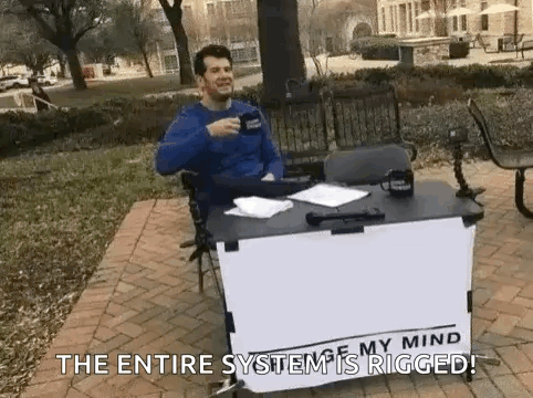 a man is sitting at a table holding a cup of coffee and talking .