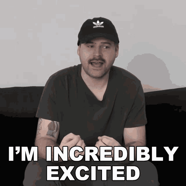 a man wearing an adidas hat is sitting on a couch and says i 'm incredibly excited