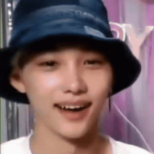 a young man wearing a blue hat and smiling .