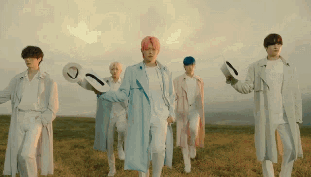 a group of young men are standing in a field holding hats and a key