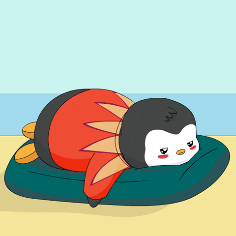 A bundled cartoon penguin sleeps face-down on a desk-like surface.