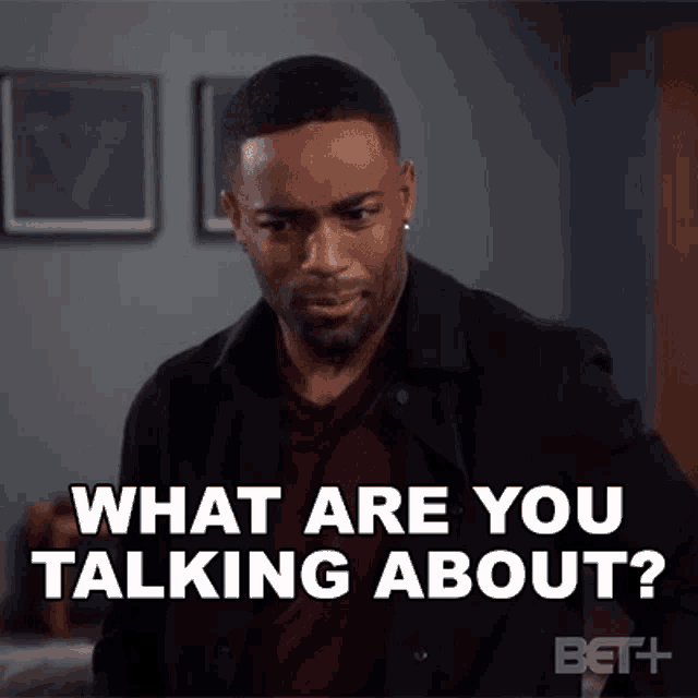 a man in a black jacket is talking about something .