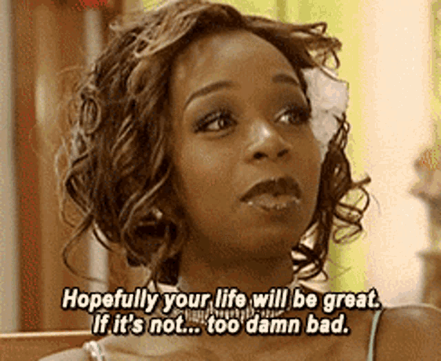 a woman with a flower in her hair is saying hopefully your life will be great if it 's not too damn bad .