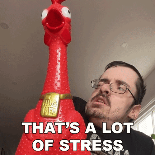 a man with glasses is holding a chicken that says hug me