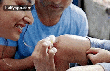 a man and a woman are sitting at a table looking at each other 's feet .