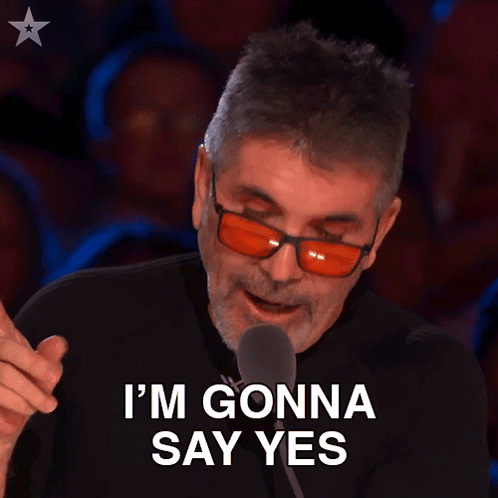 a man wearing red glasses and a black shirt says i 'm gonna say yes