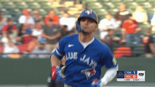 a baseball player for the blue jays is running towards the base