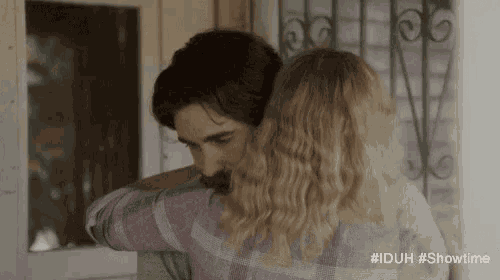 a man and a woman are hugging each other in a room .