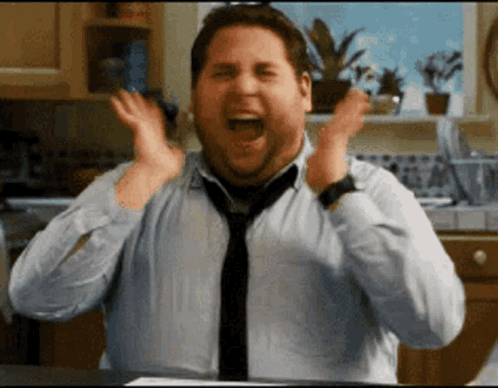 A man claps rapidly with an overjoyed expression.