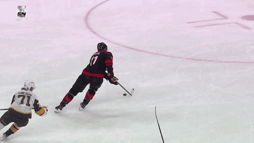 a hockey game is being played in front of a sign that says geico