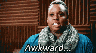 a woman wearing a scarf and a blue shirt is saying awkward