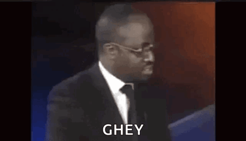 A man at a podium reacts with the caption “GHEY.”