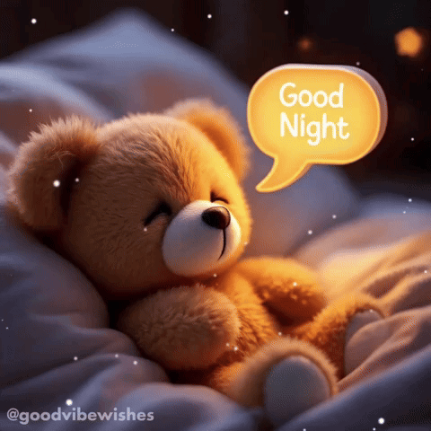 a teddy bear laying on a bed with a speech bubble saying good night