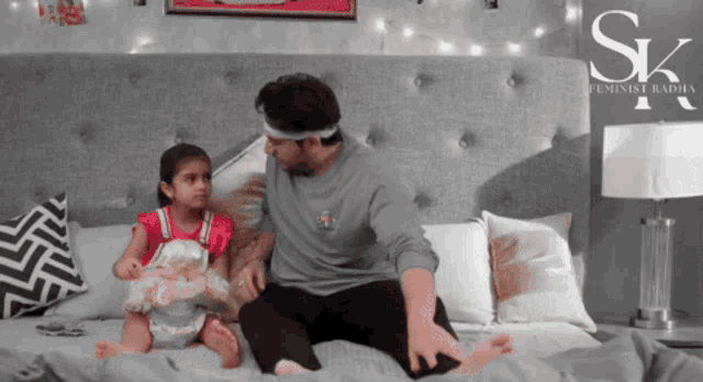 a man is sitting on a bed with a little girl and a sign that says sk