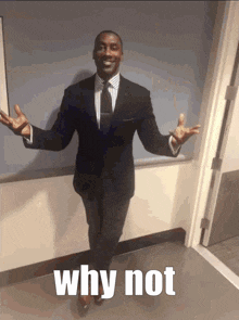 a man in a suit and tie is standing in a hallway with his arms outstretched and a caption that says why not